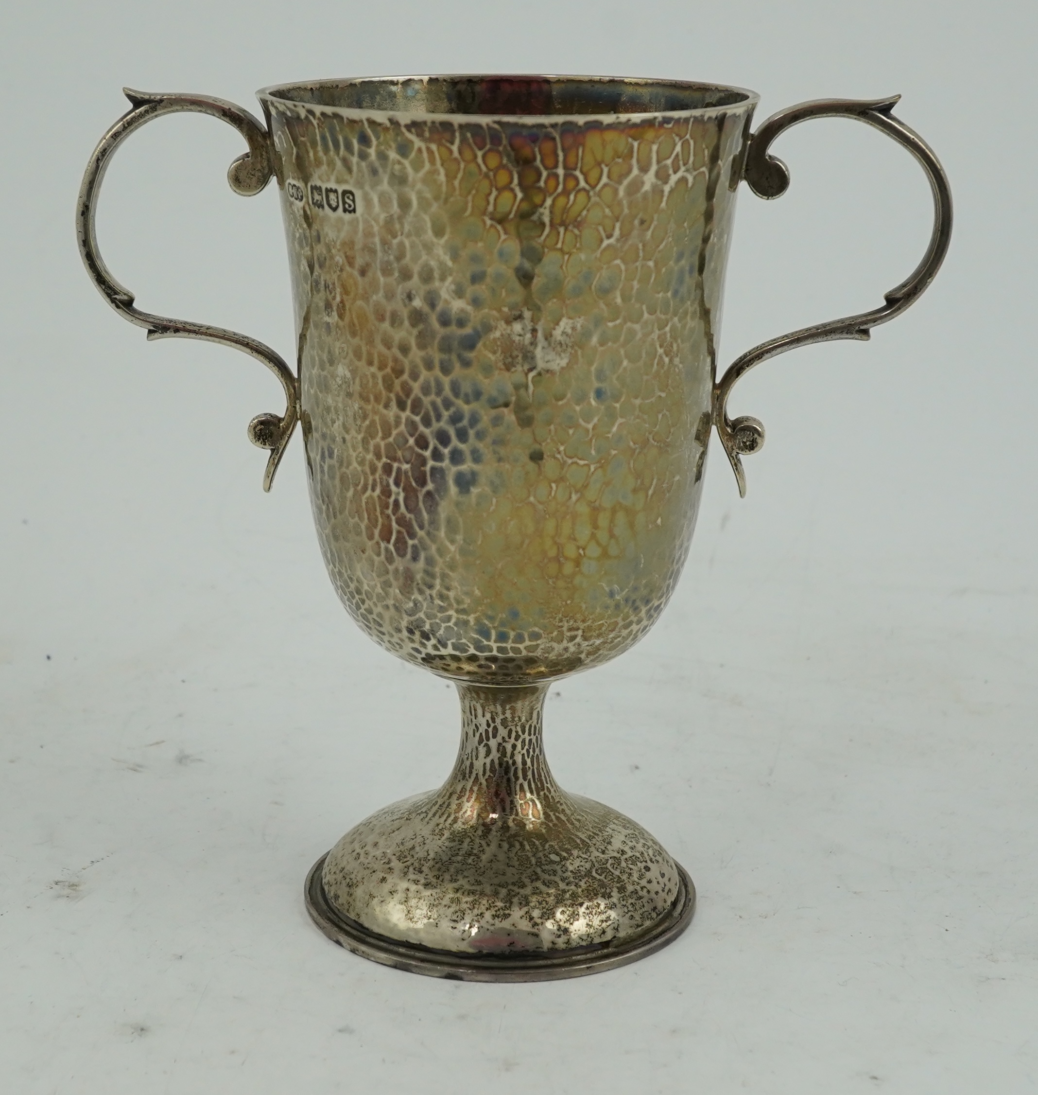 A George V planished silver two handled pedestal cup, by Henry Hodson Plante